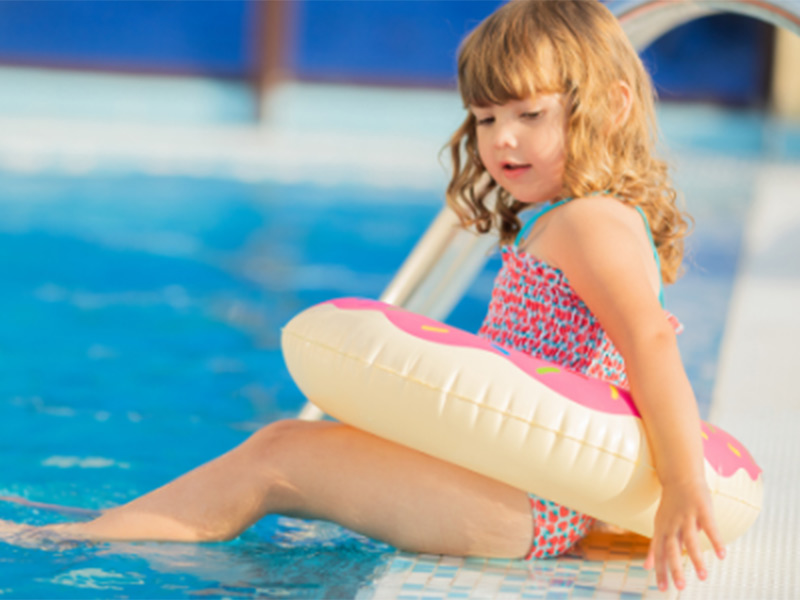 a girl playing outside of a pool